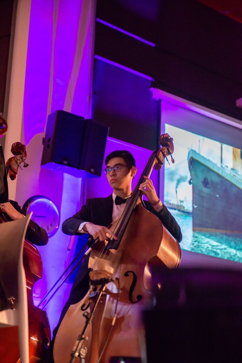 Ventus playing double bass on stage under purple lights